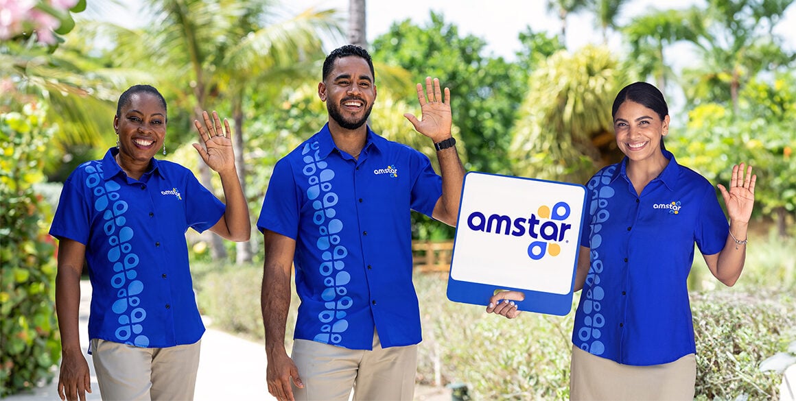 Three Amstar representatives stand side by side, one holding a sign that reads, "Amstar".