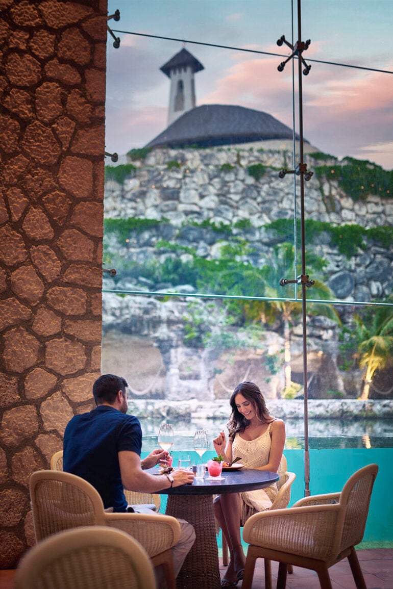 Couple dining at a restaurant with a stone church on a hill in the background