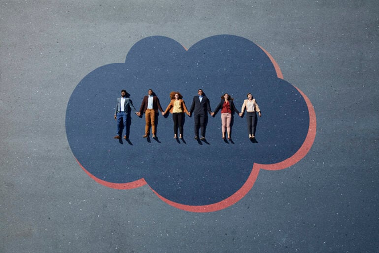 Six people laying on the ground on a painting of a cloud, holding hands