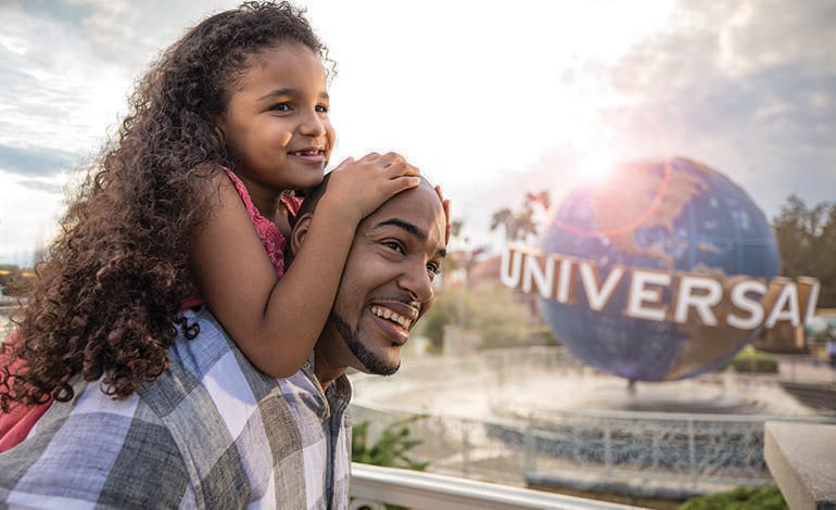 A father with his daughter at Universal Orlando Resort, with the Universal globe in the background