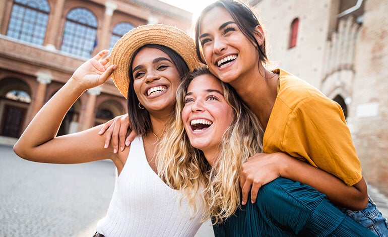 Three girl friends hugging in excitement