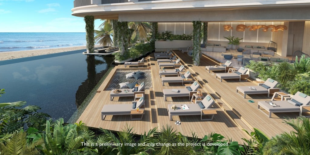 Pool deck with lounge chairs and I built-in hammock at a beachfront infinity pool