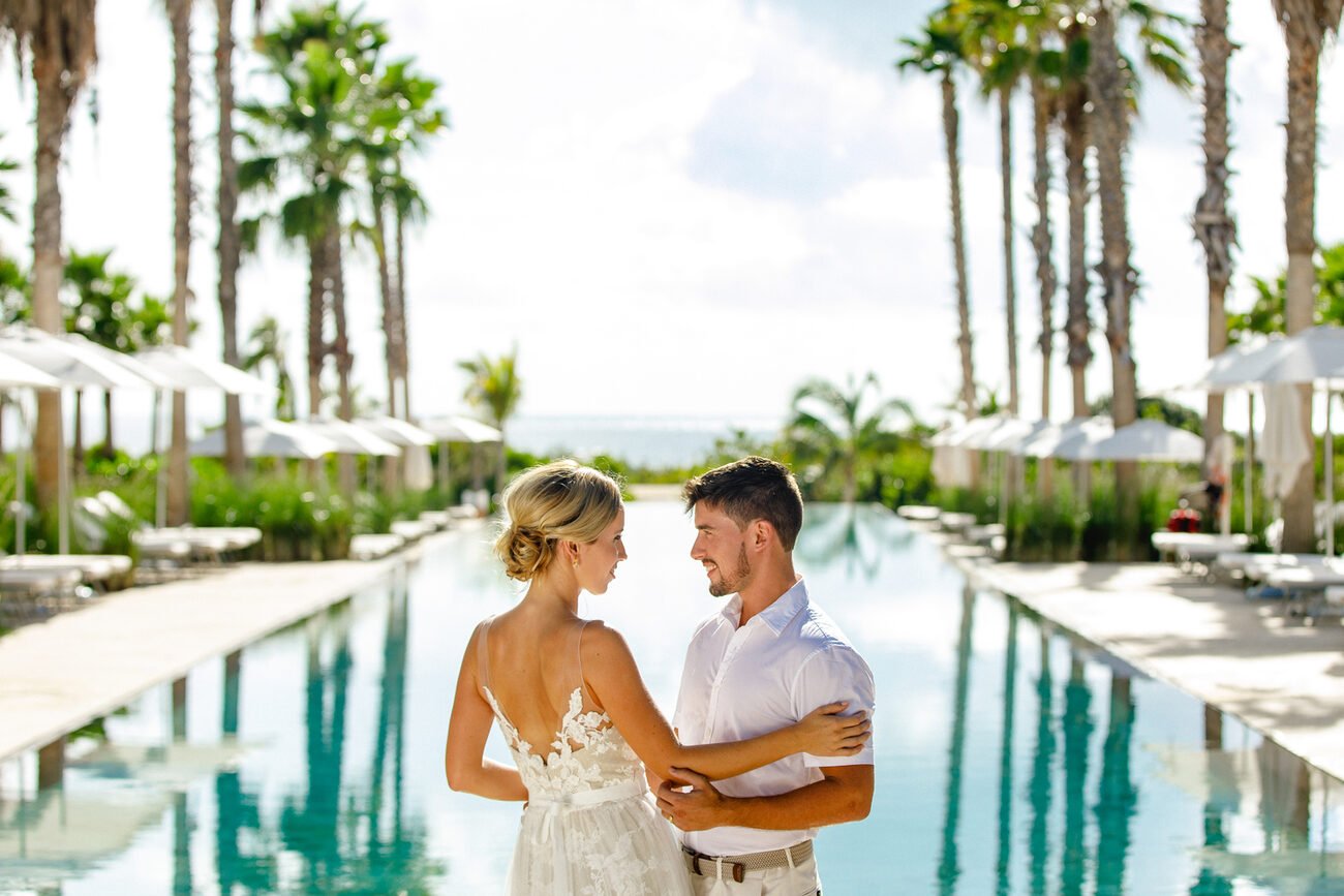 Bride and groom in front of an infinity pool.