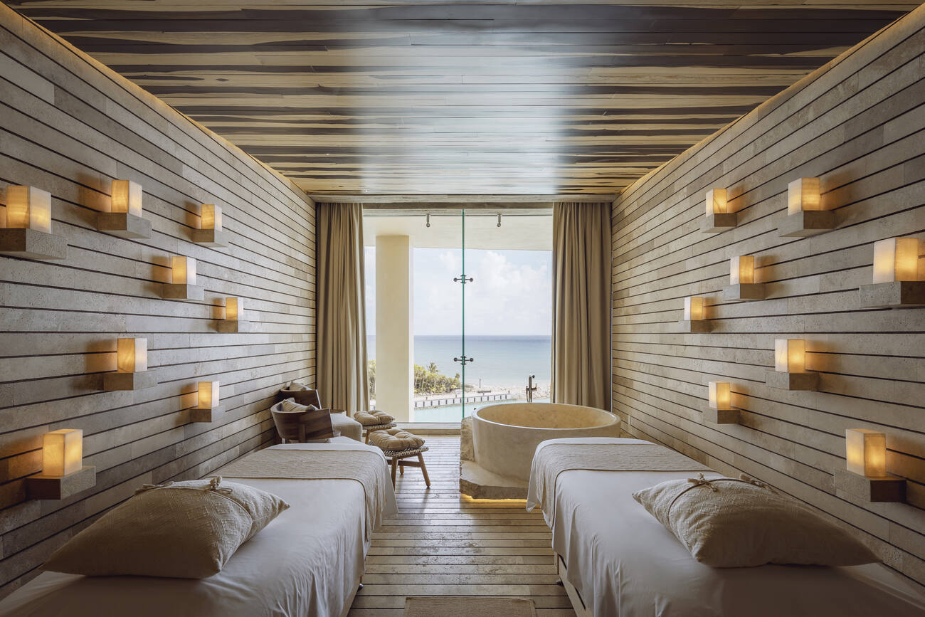 Room with two beds and bathtub overlooking the ocean