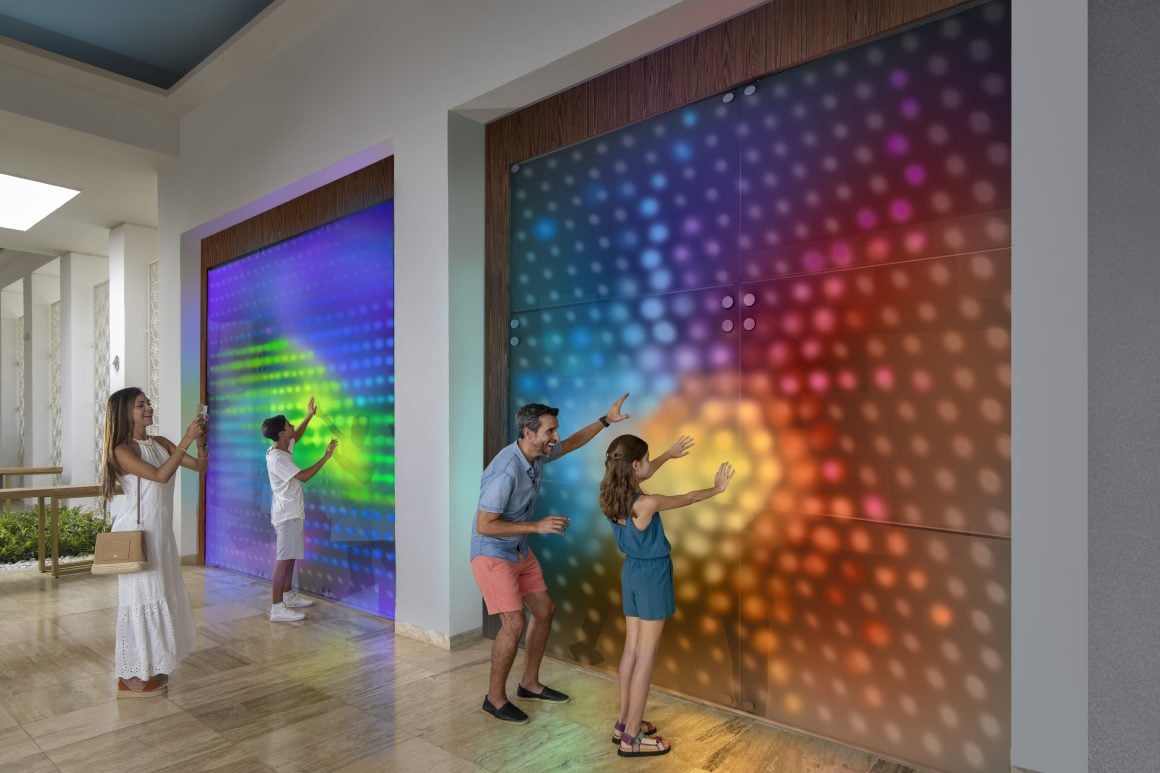 Family playing with a touch color wall interaction